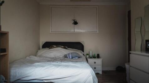 Cozy single bedroom featuring a neatly made bed...