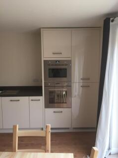 A modern and tidy kitchen featuring sleek cabin...