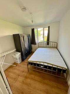 A bright double bedroom featuring a comfortable...