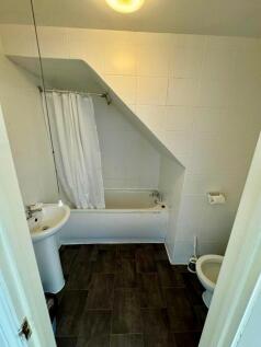 A tidy bathroom suite featuring a bath with a s...