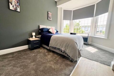 A bright and inviting single bedroom featuring ...