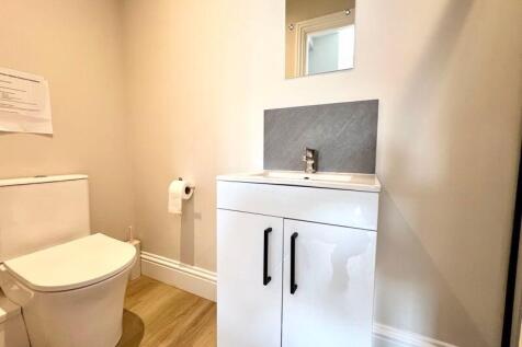 A clean and modern single toilet room featuring...