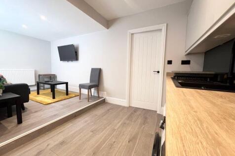 A modern and tidy living room with light wood f...