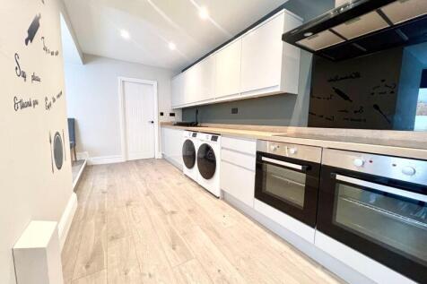 Contemporary kitchen featuring sleek white cabi...
