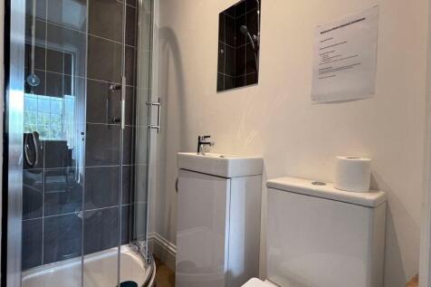 Modern bathroom featuring a spacious walk-in gl...