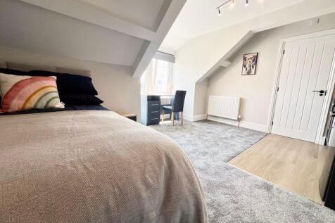 Bright and spacious master bedroom with a cozy ...