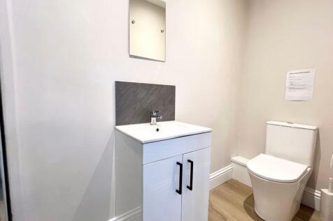 A clean and modern single toilet room featuring...