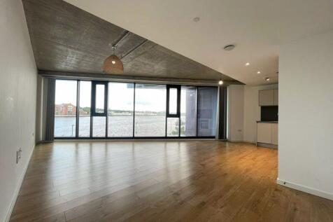 Spacious contemporary living room featuring wid...