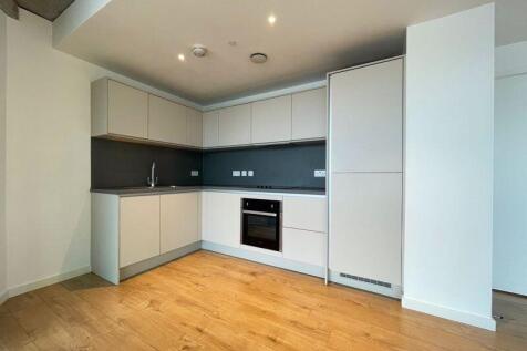A modern, clean kitchen space featuring light w...