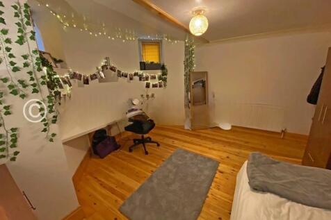 A cozy and well-organized single bedroom featur...