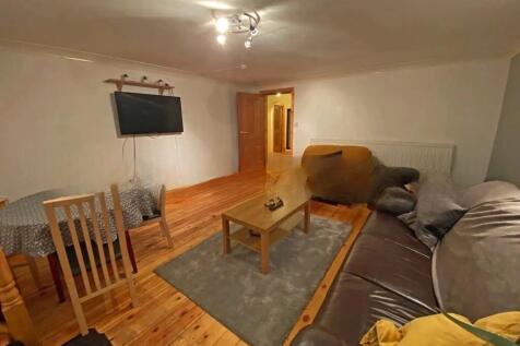 A cozy living room featuring wooden floors, com...