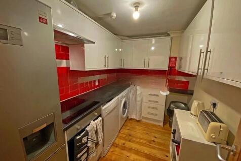 A modern kitchen featuring sleek white cabinetr...