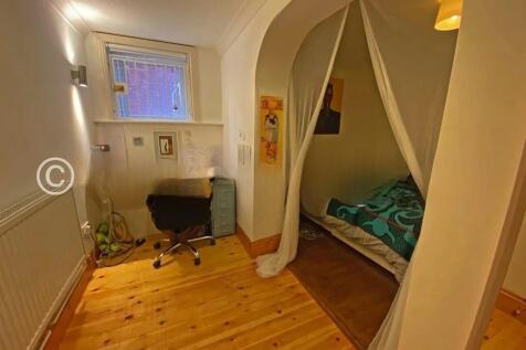 Cozy single bedroom featuring a small study are...