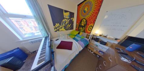 A cozy and colorful single bedroom featuring a ...