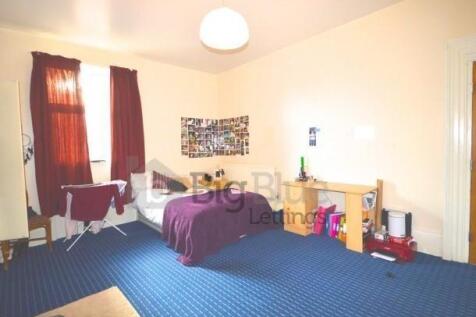 A spacious double bedroom featuring a large win...