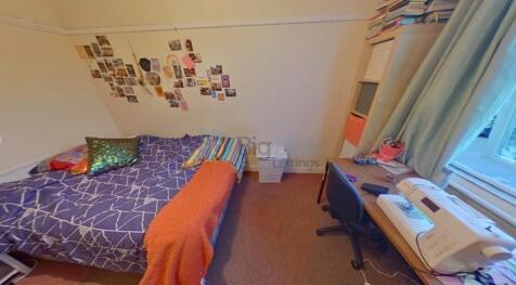 A cozy single bedroom featuring a neatly made b...