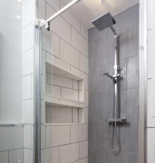 A modern bathroom shower area featuring sleek g...