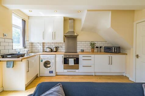Bright and modern kitchen featuring white cabin...