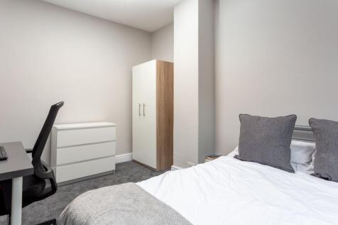 A neatly arranged double bedroom featuring a co...