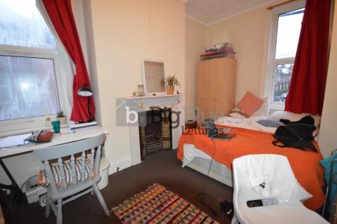 Cozy single bedroom featuring a comfortable bed...
