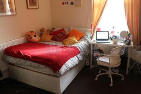 A cozy single bedroom featuring a comfortable b...