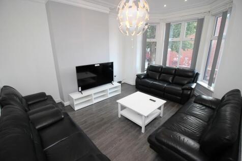 A modern living room featuring three black leat...