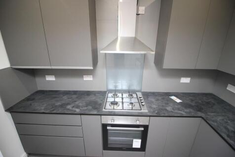 Modern kitchen featuring sleek grey cabinetry a...