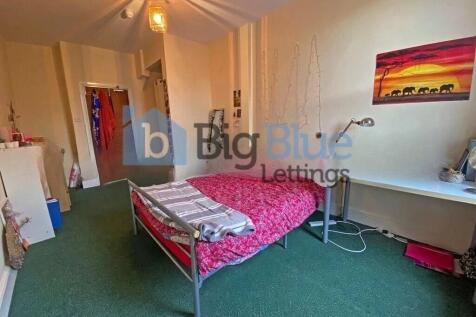 A cozy single bedroom featuring a comfortable m...