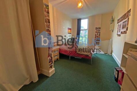 A neatly arranged bedroom featuring a single be...