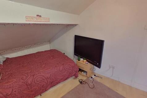 A cozy single bedroom featuring a neatly made b...