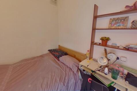 Cozy single bedroom featuring a neatly made bed...