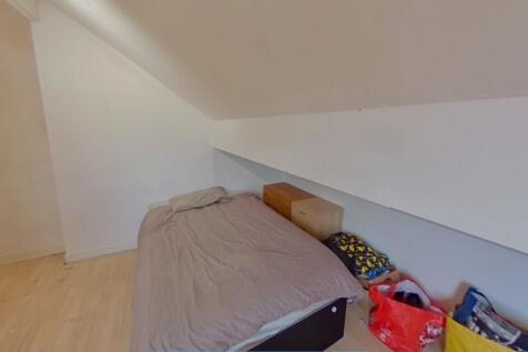 Cozy single bedroom featuring a bed with neutra...