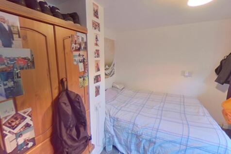 Cozy single bedroom featuring a comfortable bed...