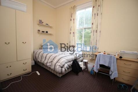 Cozy single bedroom featuring a comfortable bed...