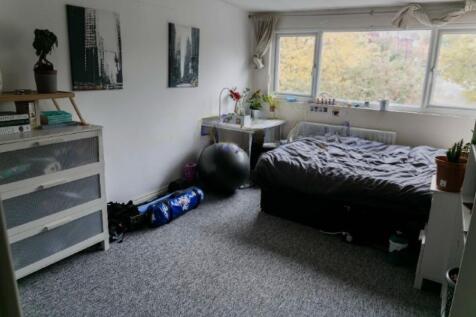 A cozy double bedroom featuring a large window ...