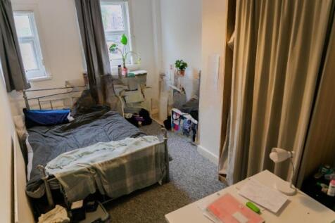 A cozy single bedroom featuring a comfortable b...