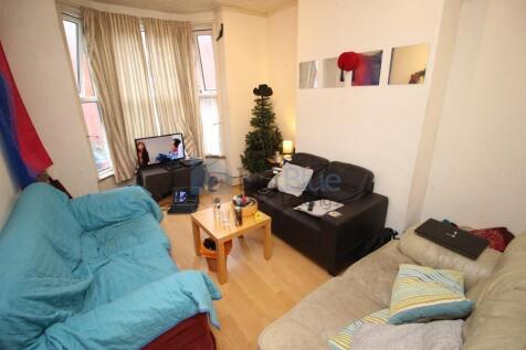 A cozy living room featuring multiple sofas arr...