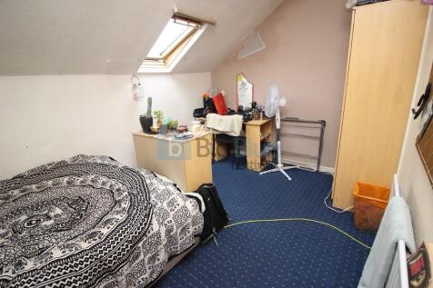 A cozy single bedroom featuring a comfortable b...