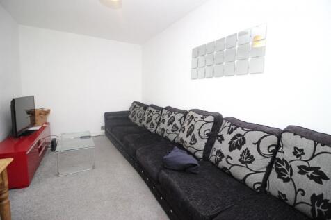 A cozy living room featuring a long black patte...