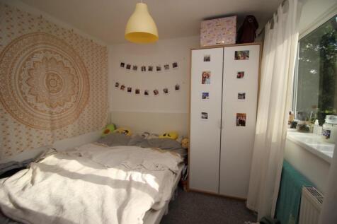 A cozy single bedroom featuring a comfortable b...