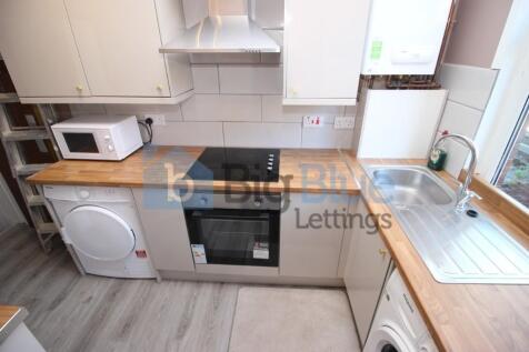 A tidy and modern kitchen featuring light wood ...