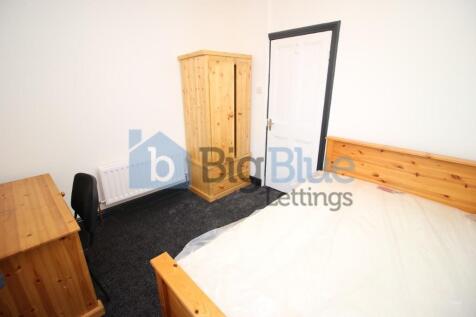 A cozy and well-kept bedroom featuring a wooden...