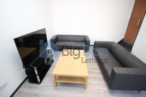 A modern living room featuring two black sofas ...