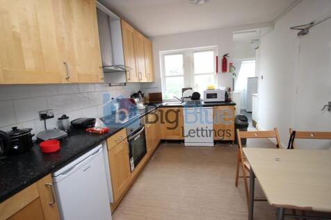 Bright and tidy kitchen featuring wooden cabine...
