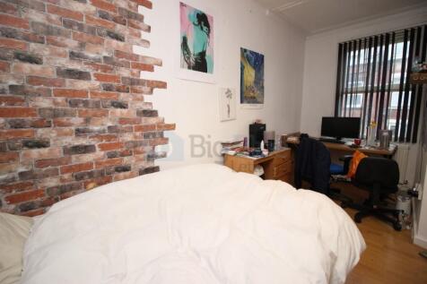 A cozy bedroom featuring an exposed brick wall ...