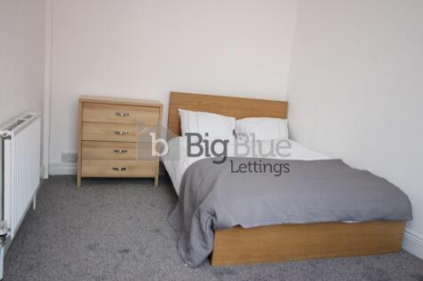 A clean and cozy single bedroom featuring a woo...