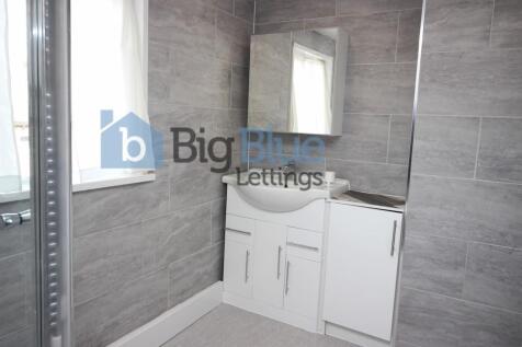 Modern bathroom with sleek grey tiled walls and...