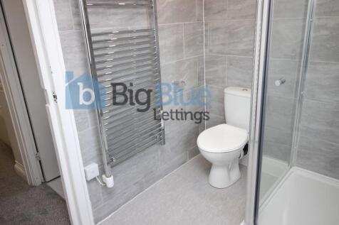 Modern bathroom featuring sleek grey tiled wall...