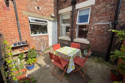 A charming and cozy outdoor garden area with a ...