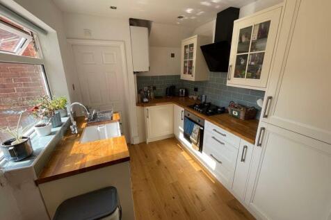 Bright and modern kitchen featuring cream cabin...